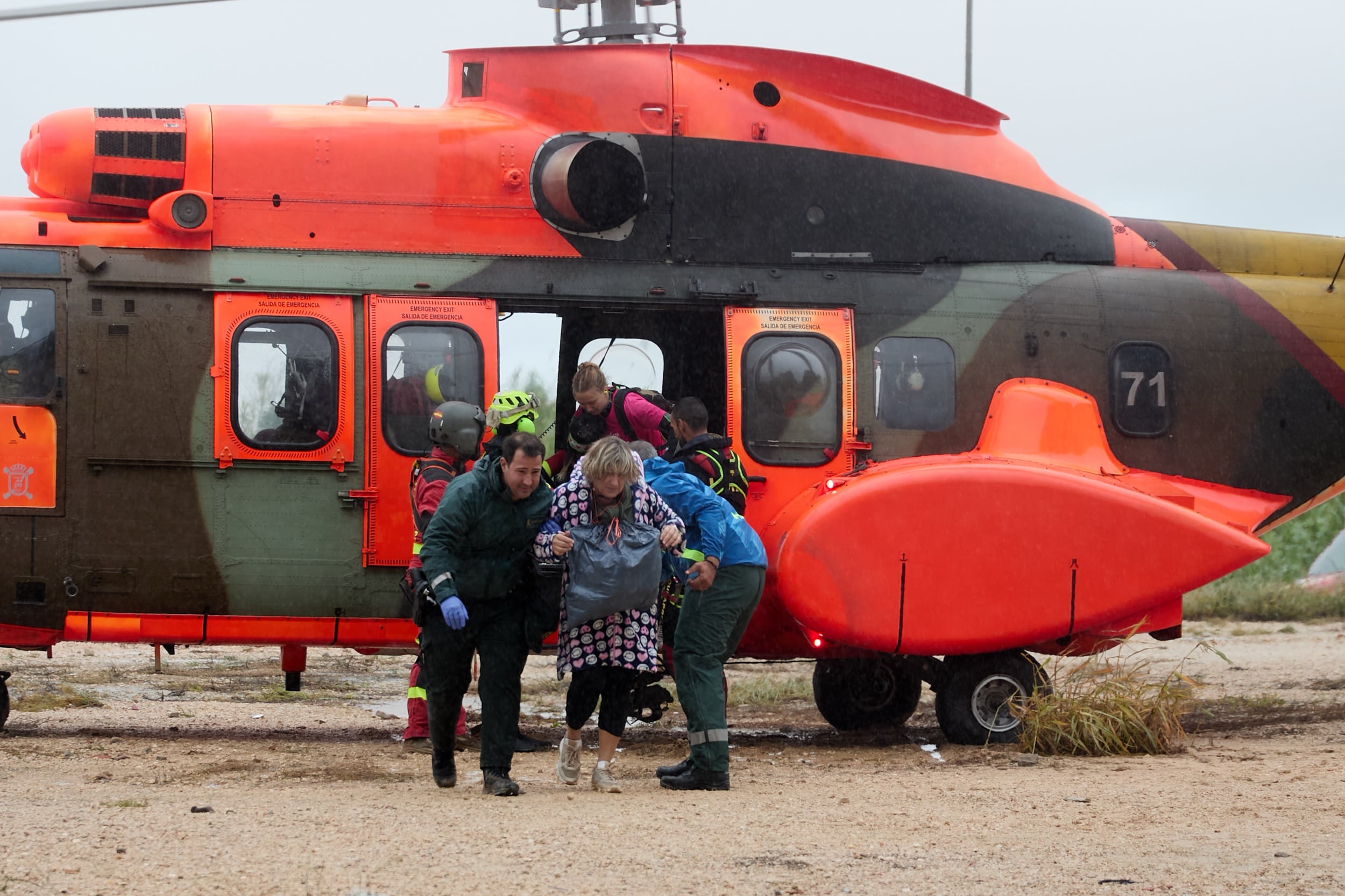 Varios vecinos se bajan de un helicóptero de los servicios de emergencia tras ser rescatados en la localidad de Oliva. (Natxo Francés/EFE)