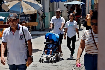 LA HABANA (CUBA), 24/08/2026.- Fotografía del 20 de agosto de 2026 que muestra a una pareja caminando con un niño en La Habana (Cuba). El embarazo adolescente en Cuba es considerado un "serio problema social y de salud" por las autoridades de la isla, donde en torno al 18-19 % de los nacimientos son de madres de entre 15 y 19 años. EFE/ Ernesto Mastrascusa
