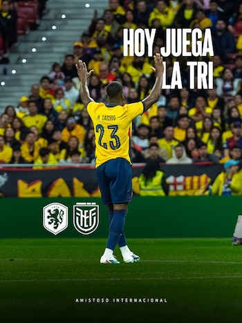 El futbolista Moisés Caicedo, con la camiseta amarilla número 23 de Ecuador, de espaldas y brazos alzados, en un campo de fútbol con público