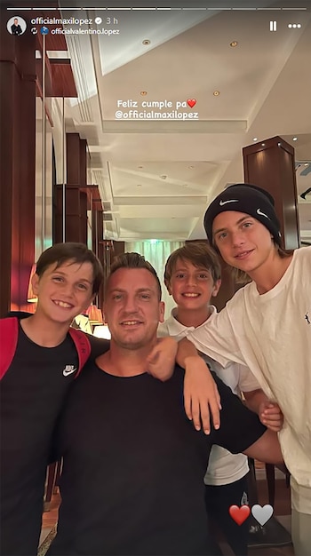 Maxi López, sonriente, posa abrazado por sus tres hijos de distintas edades, en un interior con iluminación cálida y paneles de madera oscura