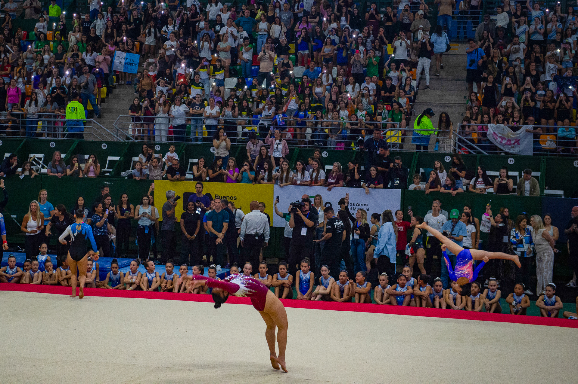 Biles y su entrenador siguen la demostración de las gimnastas de la selección argentina