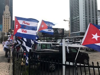 Personas ondean banderas cubanas con