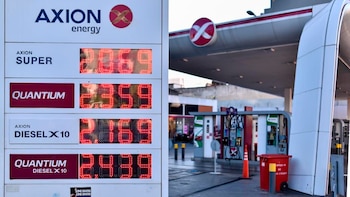 Cartel digital de precios de combustibles Axion Energy a la izquierda, y surtidores de una estación de servicio Axion a la derecha