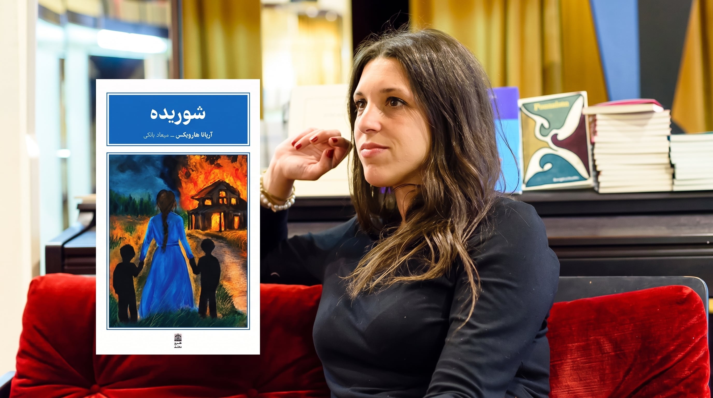 La escritora argentina Ariana Harwicz posa junto a la portada de la edición traducida al persa de su novela