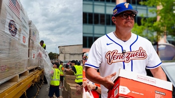 Un camión con palés de cajas envueltas en plástico, banderas estadounidenses y logos de los Houston Astros, junto a un hombre con camiseta de béisbol de Venezuela