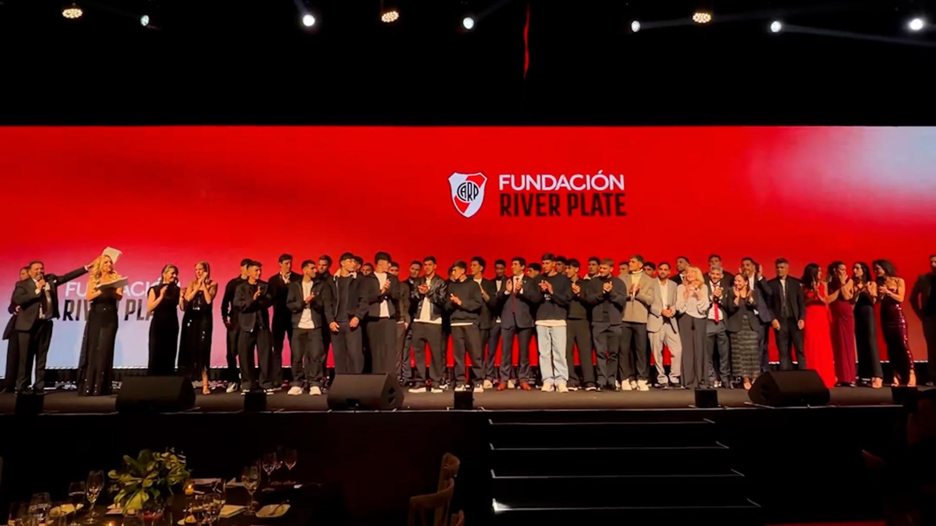 Integrantes del plantel y autoridades del club se reúnen en el escenario durante el cierre de la cena anual de la Fundación River Plate.