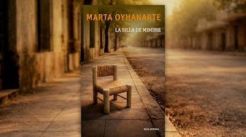 Portada del libro 'La Silla de Mimbre' de Marta Oyhanarte, con una silla de mimbre en una acera y una calle arbolada al fondo, bajo una luz cálida y difusa.