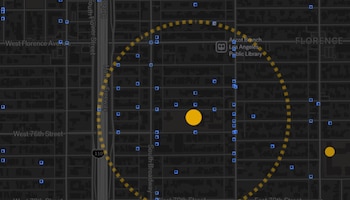Un mapa oscuro con calles, bloques, un círculo amarillo central, otro círculo amarillo, un radio de línea discontinua y numerosos cuadrados azules
