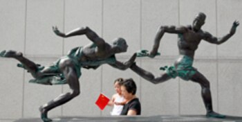 Visitors walk past a sculpture