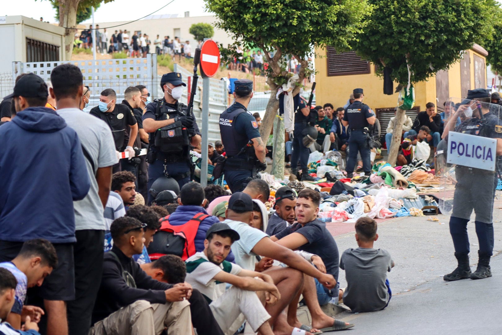 Varios grupos de migrantes frente a la explanada de embotellamiento de Loma Colmenar. (EFE/Reduan)