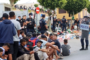 Varios grupos de migrantes frente a la explanada de embotellamiento de Loma Colmenar. (EFE/Reduan)