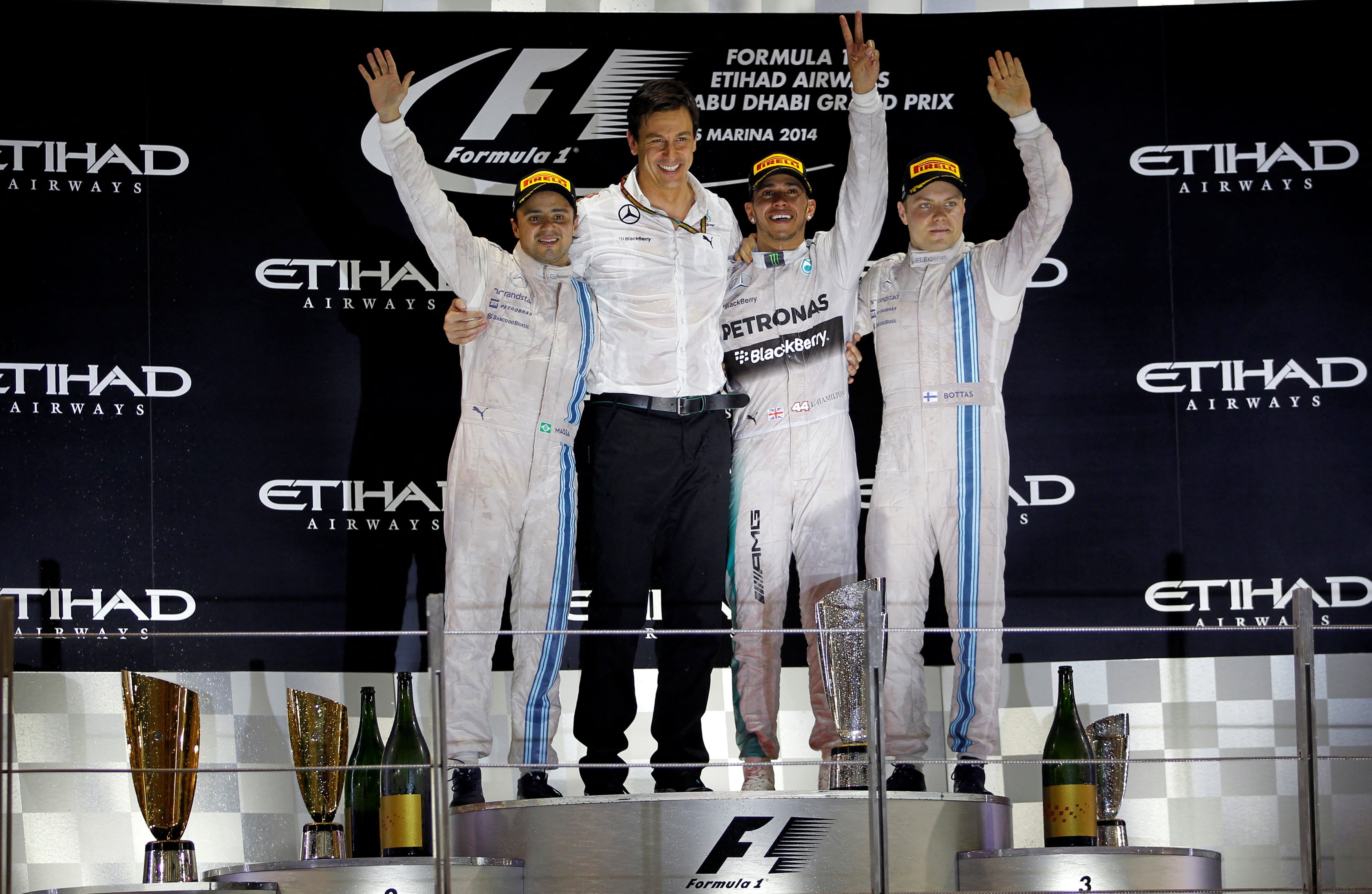 Valtteri Bottas celebra el tercer puesto en Abu Dhabi 2014. En el medio el medio el ganador, Lewis Hamilton, el jefe de Mercedes, Toto WolFf, y a la izquierda, Felipe Massa, quien resultó segundo (REUTERS/Hamad I Mohammed)