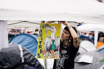 Una chica cuelga un cartel en la acampada, en la Puerta del Sol (Madrid). (Carlos Luján / Europa Press)