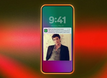 Un smartphone con borde dorado muestra su pantalla de bloqueo, la hora 9:41 y una notificación de Spotify con la foto de un hombre joven