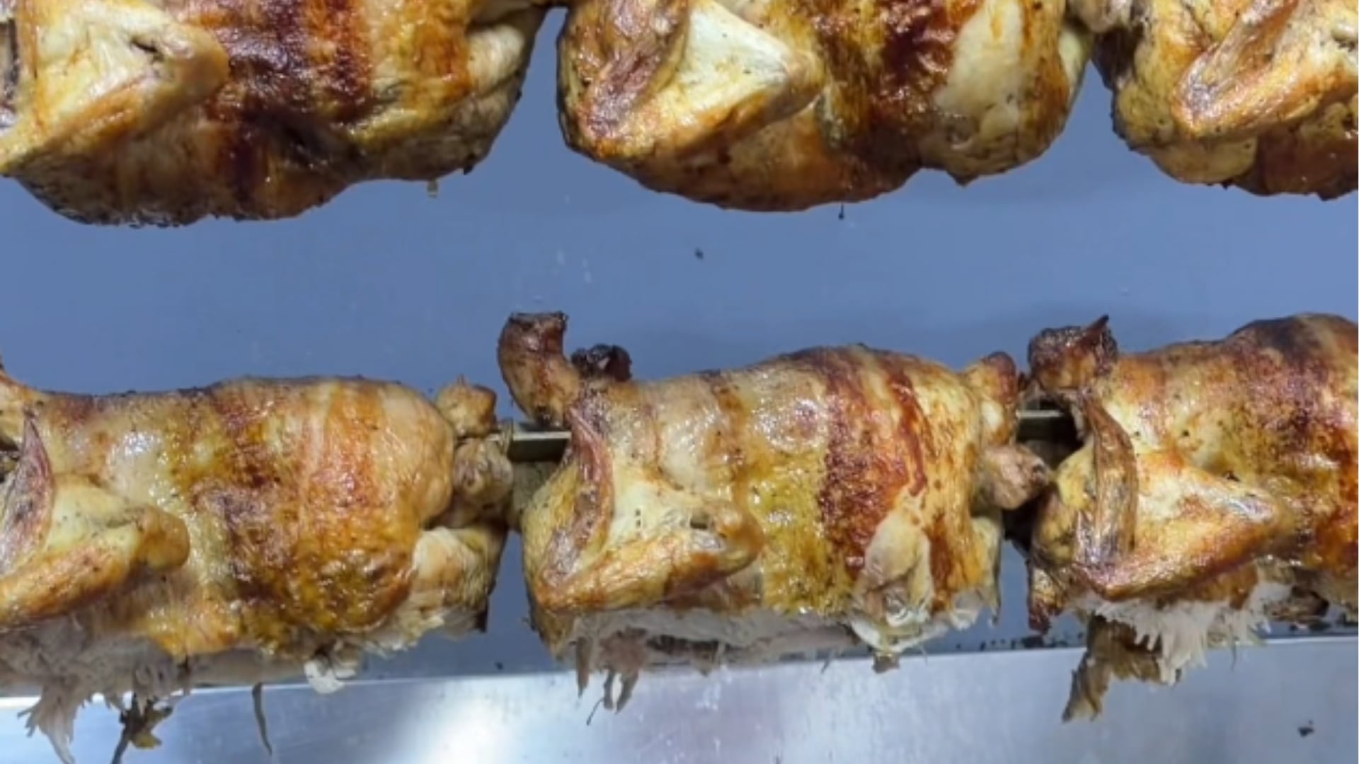 Un grupo de pollos a la brasa permanece en las varillas de un asador dentro del restaurante donde un perro consumió tres piezas expuestas. (TikTok/@doshumanosypancho)