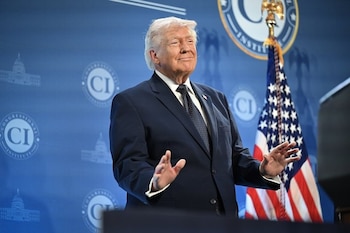 Donald Trump con traje azul y corbata oscura, de pie, manos levantadas. Fondo azul con logos del Congressional Institute y bandera de Estados Unidos
