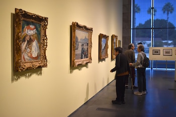 Personas observan las obras exhibidas