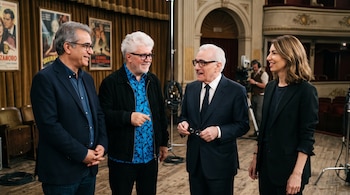 Jafar Panahi, Pedro Almodóvar, Martin Scorsese y Sofia Coppola de pie en un escenario con afiches de cine y equipo de filmación.