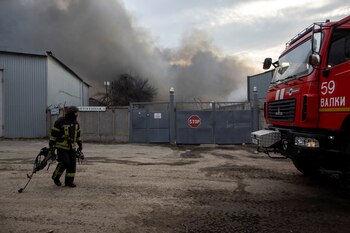 A firefighter carries his gear