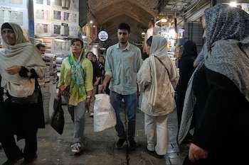 Compradores acarrean paquetes en el histórico Gran Bazar de Teherán, el lunes 1 de junio de 2026. La inflación en bienes de primera necesidad —medicamentos, transporte y comunicaciones— trepó un 113,8 % respecto al año anterior. (AP Photo/Vahid Salemi)