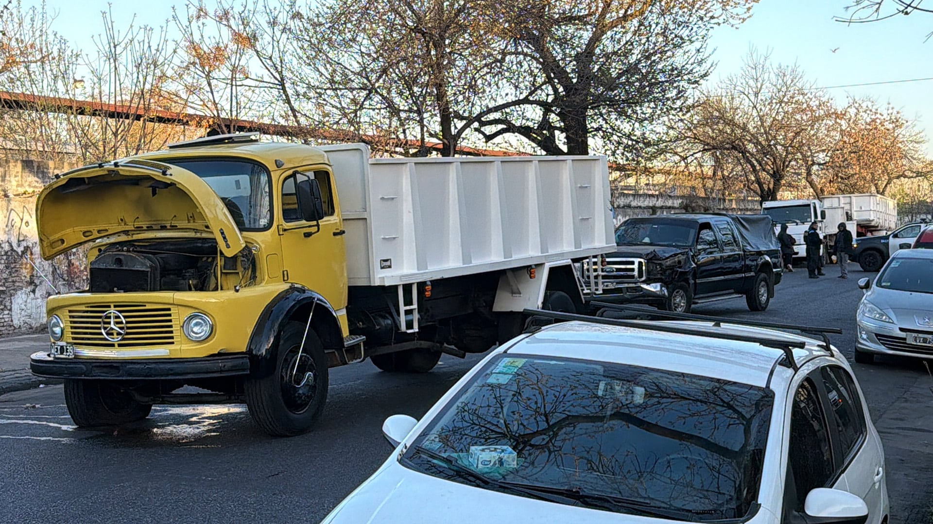 Un camión con el capó levantado y una camioneta con daños frontales permanecen en la calle tras un choque en el barrio de Mataderos.