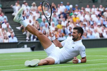 El serbio Novak Djokovic sentado en el césped tras responder a un tiro de su compatriota Miomir Kecmanovic en la tercera ronda de Wimbledon el sábado 5 de julio del 2025. (AP Foto/Kirsty Wigglesworth)