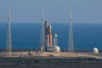 Cohete de la NASA en plataforma de lanzamiento bajo cielo nublado