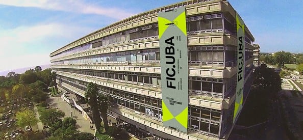 Un edificio de la Universidad de Buenos Aires exhibe grandes carteles amarillos del Festival Internacional de Cine FIC.UBA en su fachada.