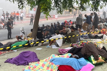 Decenas de personas se concentran cerca del embolsamiento de Loma Colmenar con la esperanza de conseguir una plaza en un nuevo centro de acogida. (EFE/Reduan)