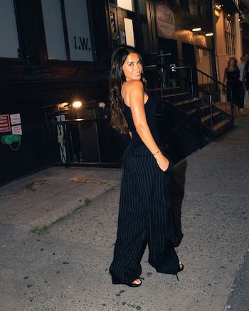 Antonela Roccuzzo combinó un top ajustado con un pantalón de pierna ancha y raya diplomática