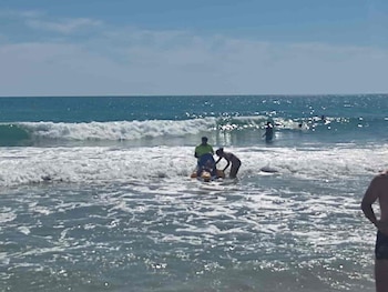 Una familia disfruta del mar en la playa de Calafell, en una jornada de verano,