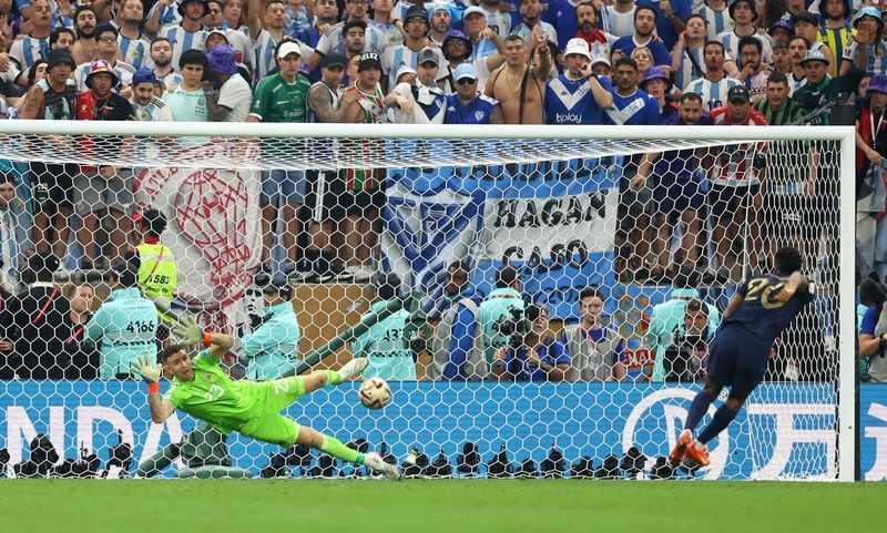 Emiliano Martinez ataja el tiro de Kingsley Coman en la definición por penales de la final del Mundial ante Francia (REUTERS/Carl Recine)