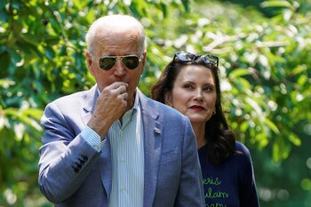 U.S. President Joe Biden eats a cherry as he tours King Orchards with Michigan Governor Gretchen Whitmer in Central Lake, Michigan, U.S., July 3, 2021. REUTERS/Joshua Roberts