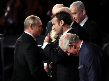 El presidente francés Emmanuel Macron conversa con su homólogo ruso, Vladimir Putin, durante la ceremonia. Foto: Abir Sultan/REUTERS