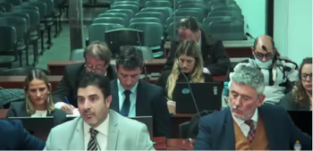 El fiscal Diego Velasco alega en Sueños Compartidos. Dos filas atrás está sentado el acusado Pablo Schoklender, con un barbijo que le cubre parte del rostro