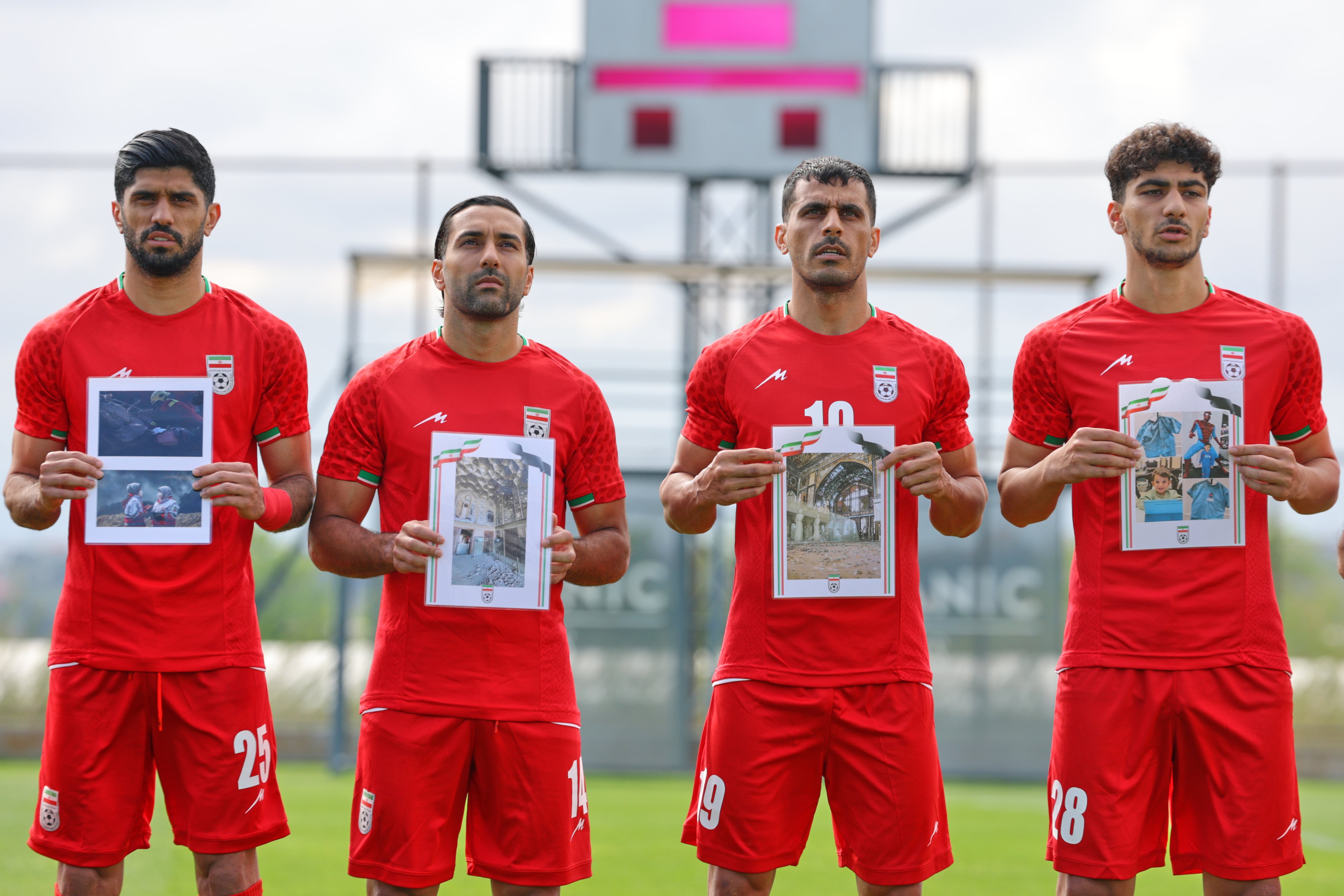 Jugadores iraníes cantan el himno nacional, sosteniendo fotografías de niños presuntamente asesinados en ataques estadounidenses e israelíes en Irán, antes de un partido amistoso de fútbol entre Irán y Costa Rica, en Antalya, al sur de Turquía, el martes 31 de marzo de 2026. (Foto AP/Riza Ozel)