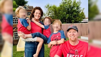 Un hombre, una mujer y tres niños con rostros difuminados posan sonrientes en un jardín junto a una pequeña casa de madera
