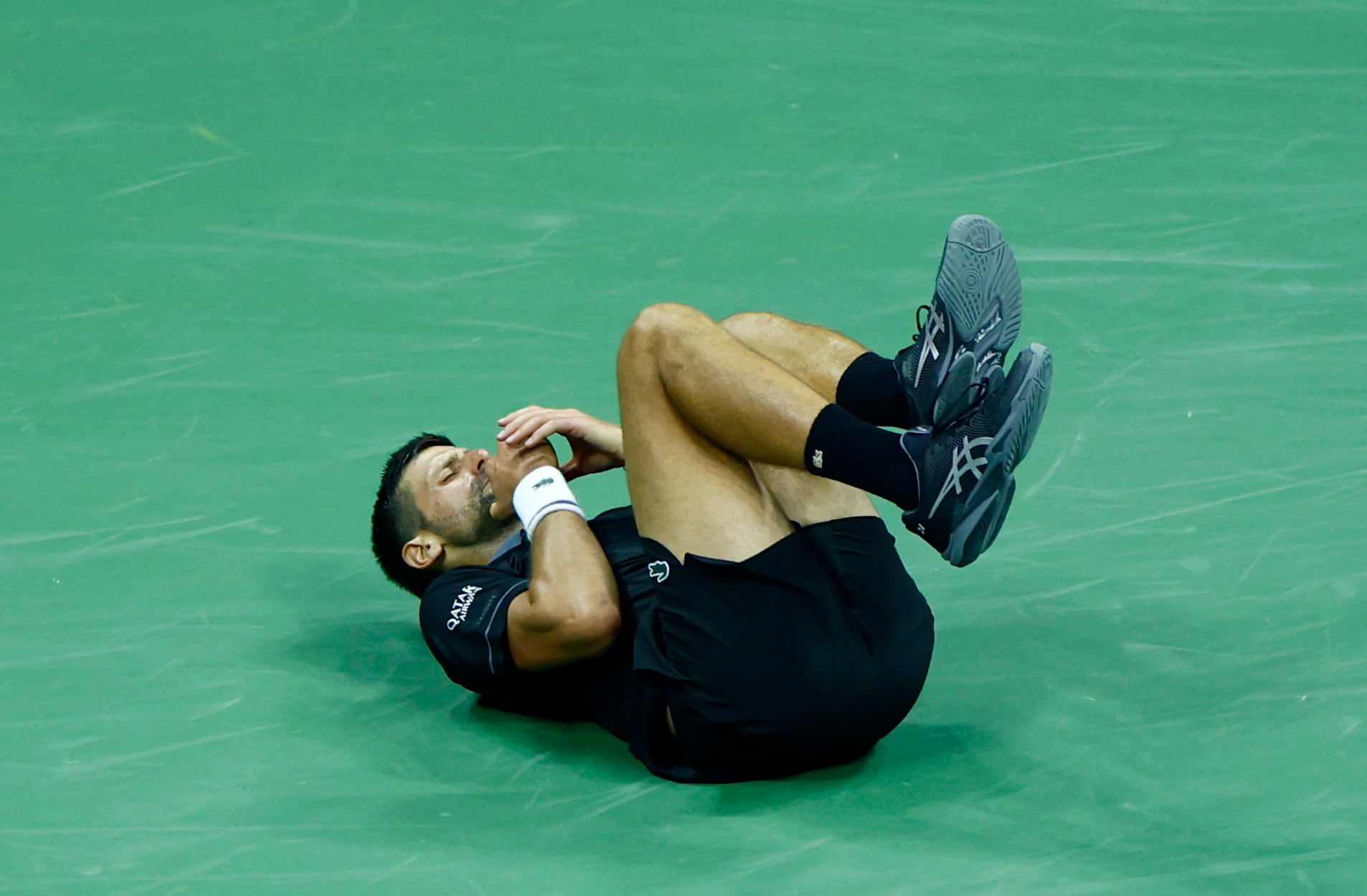 Novak Djokovic cae sobre la pista del estadio Arthur Ashe durante su partido ante Mariano Navone en el US Open (Crédito: REUTERS/Jeenah Moon)