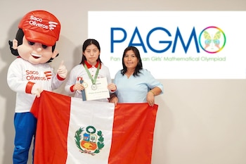 Una joven con medalla y diploma, una mujer y una botarga sostienen la bandera de Perú frente a una pantalla con el logotipo de la PAGMO