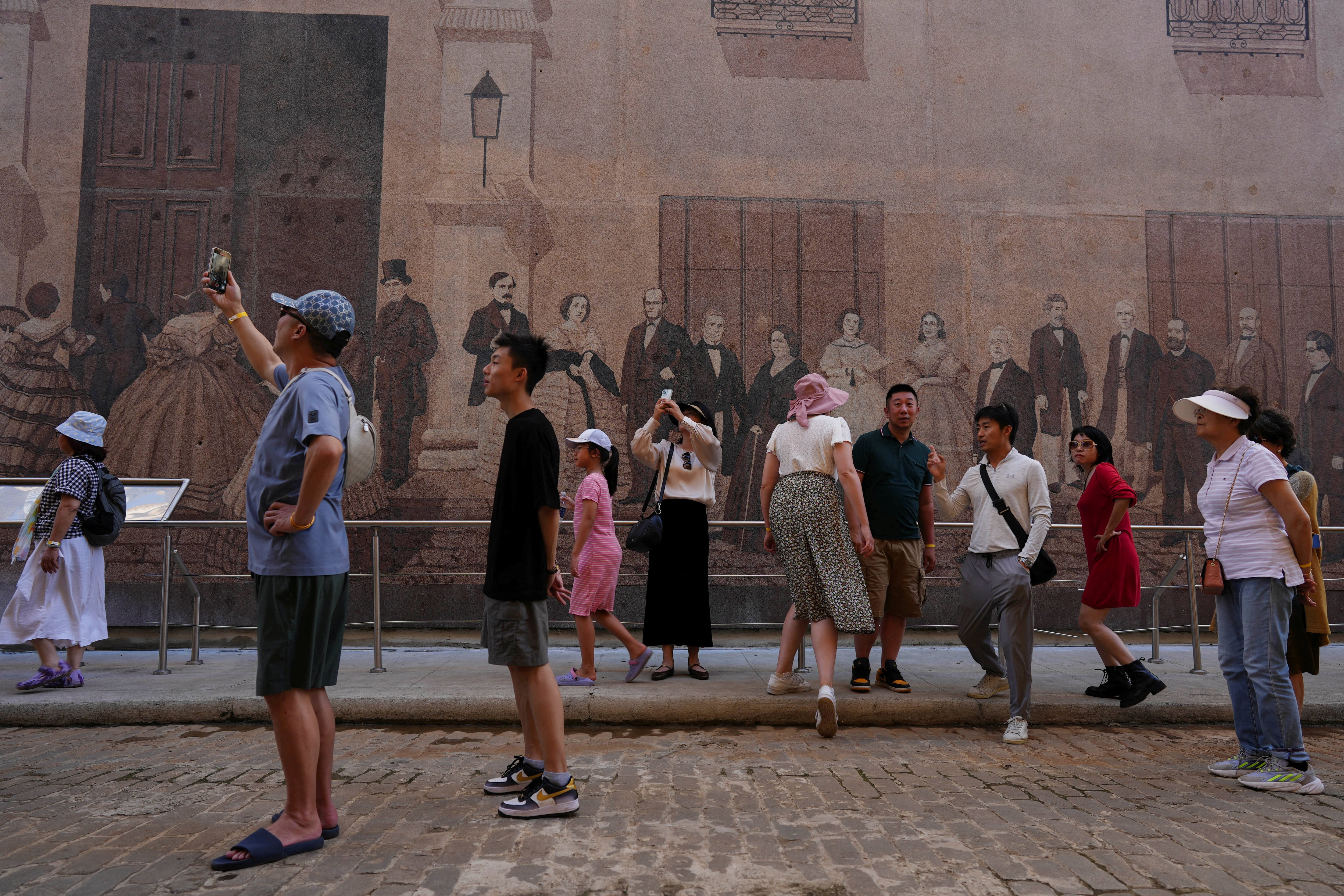 Turistas toman fotografías en el centro de La Habana, Cuba, 18 de diciembre de 2024. REUTERS/Alexandre Meneghini