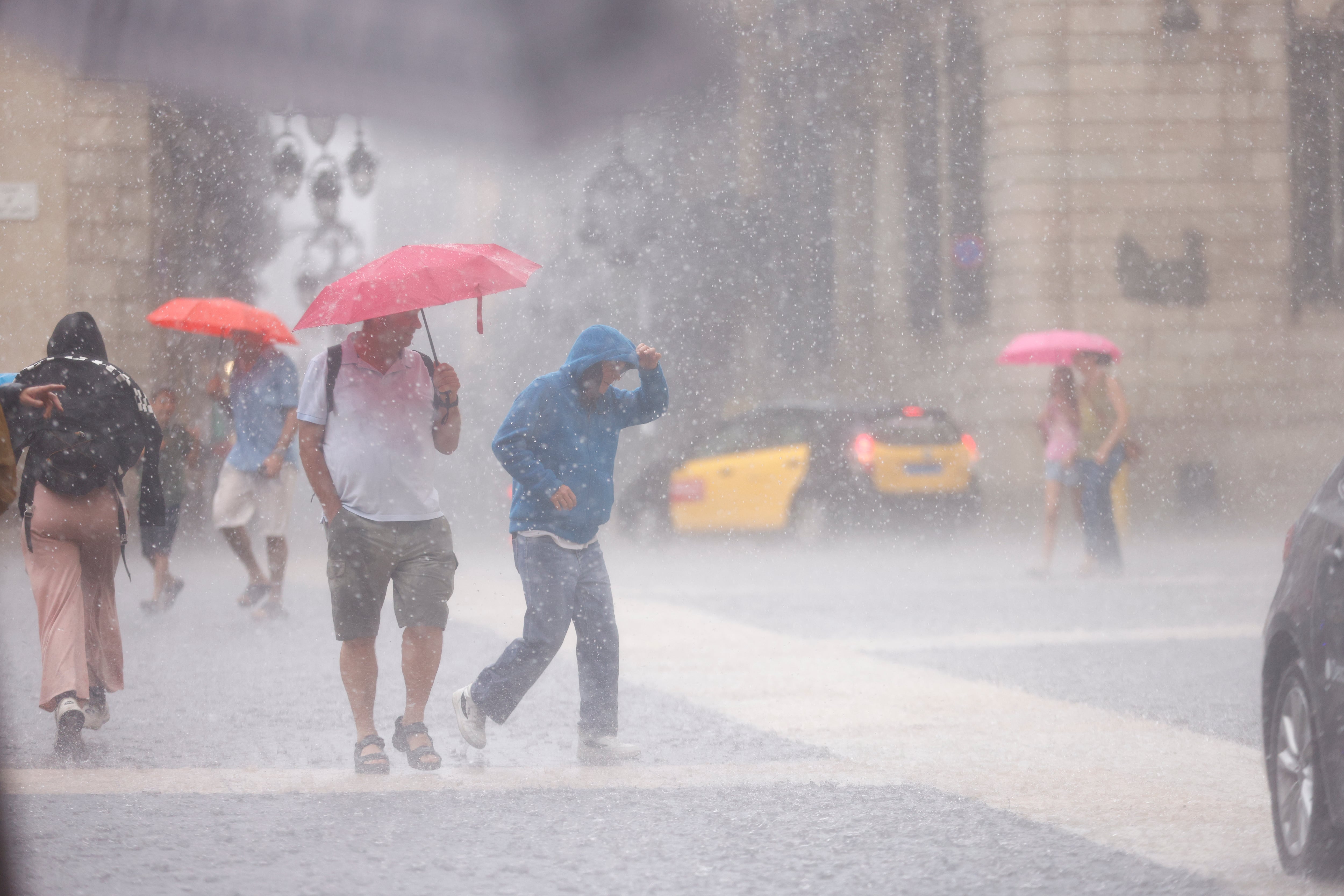 Personas se protegen de la lluvia en el centro de Barcelona, a 11 de septiembre de 2025. (EFE/ Quique García)