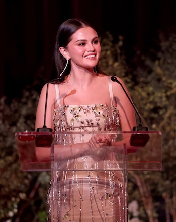 Para el evento principal, Selena Gomez cambió el rojo por un vestido champán de Prada de silueta fluida