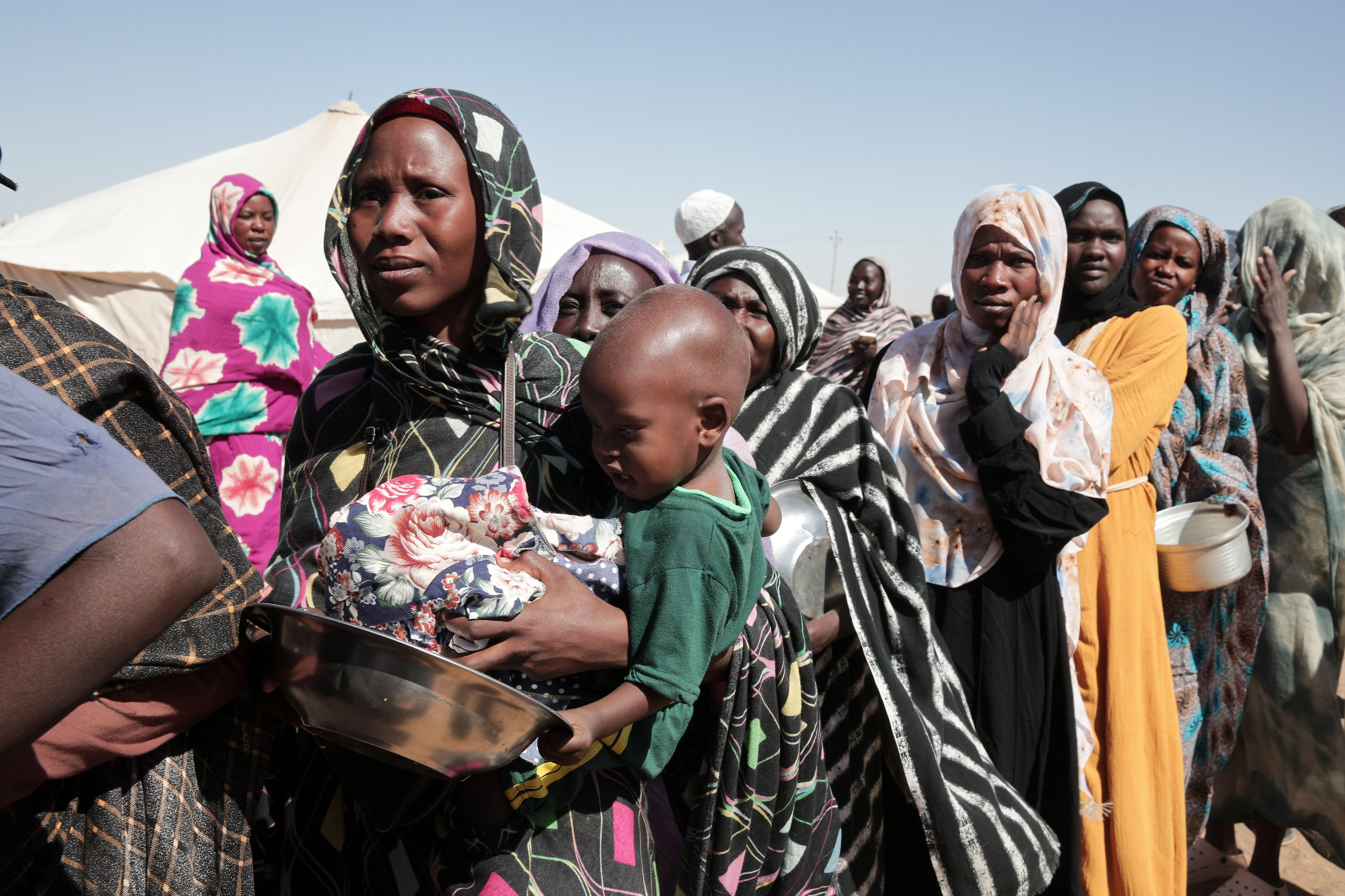 ARCHIVO - Mujeres desplazadas de El-Fasher hacen fila para recibir ayuda alimentaria en el campamento recién formado de El-Afadh camp en Al Dabbah, en el estado de Sudán del Norte, el 16 de noviembre de 2025. (AP Foto/Marwan Ali, Archivo)