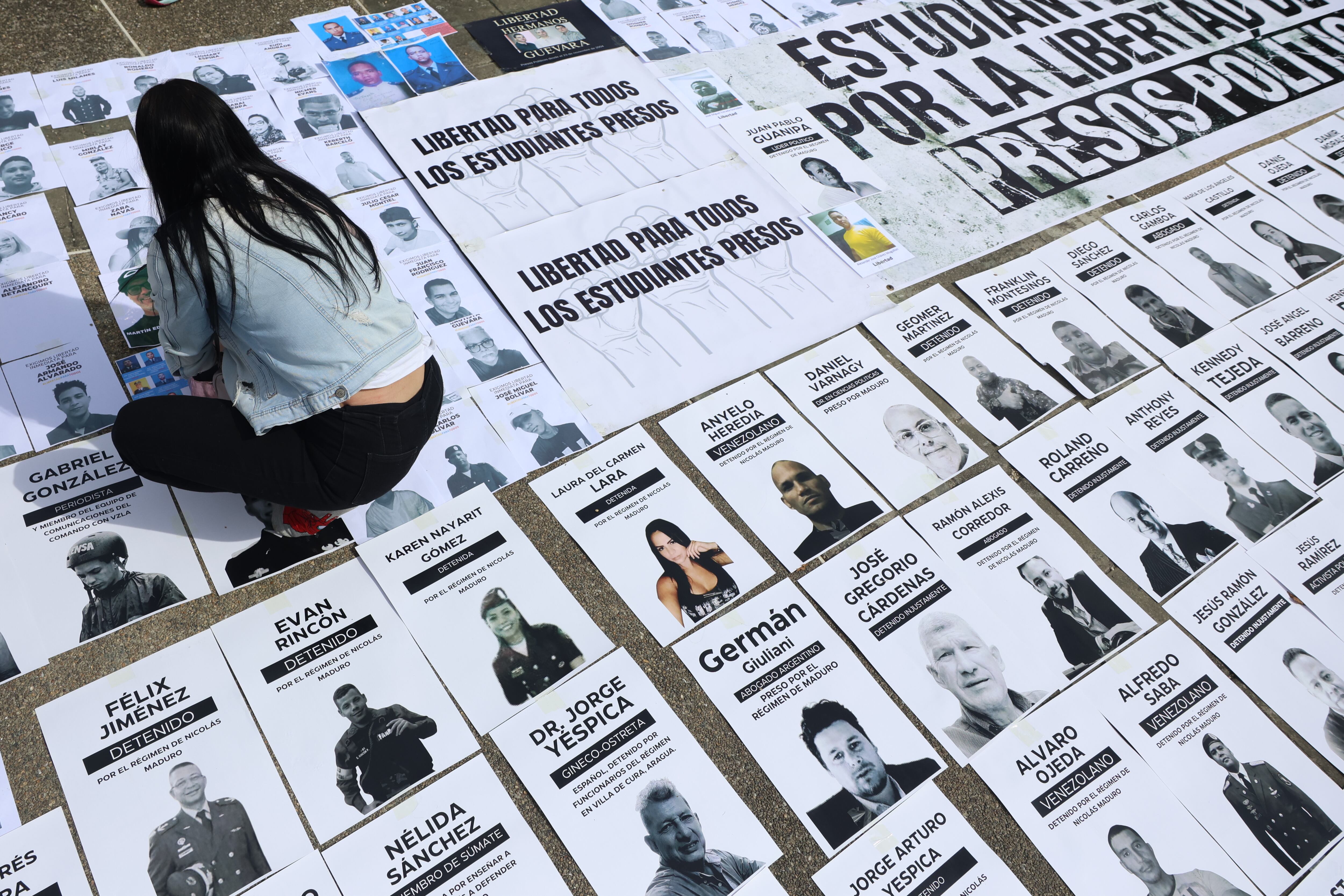 Una persona organiza carteles con imágenes de presos políticos este martes, en la Plaza del Rectorado UCV, en Caracas (Venezuela) (EFE/ Miguel Gutiérrez)