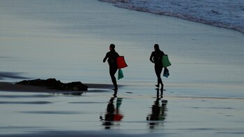 Dos surfistas en la playa