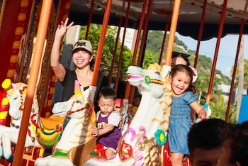Familias disfrutan del carrusel en uno de los parques recreativos del ISTU, espacios diseñados para la convivencia y el entretenimiento seguro de niños y adultos (Foto cortesía @ISTUSV).