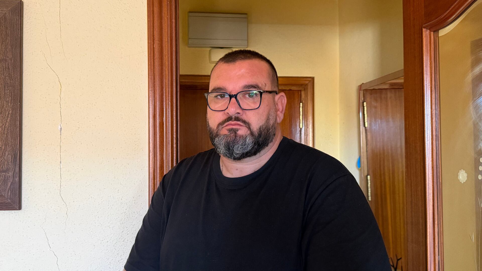 David Casado, vecino de San Fernando de Henares, junto a una de las grietas que muestran las paredes de su casa. (Lydia Hernández Téllez/Infobae España)