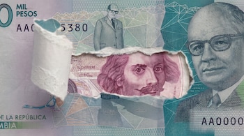 Un billete colombiano de cien mil pesos con un corte en el papel que deja al descubierto la cara de un billete italiano en tono rosado.