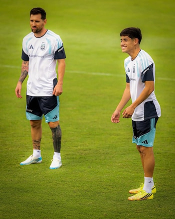 Thiago Almada con uniforme de fútbol celeste y oscuro, frente a un balón multicolor en un campo de césped con un pequeño arco al fondo