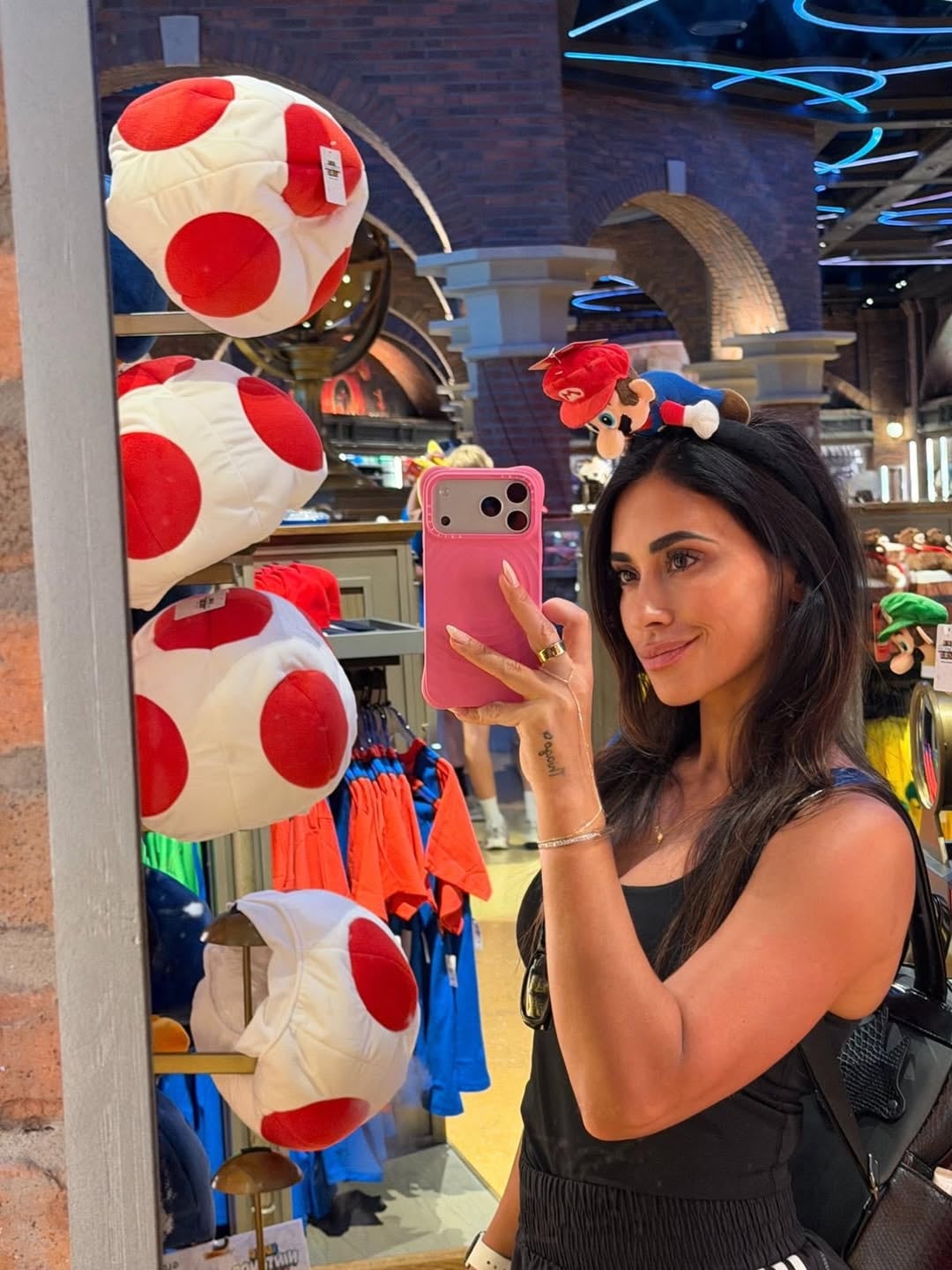 Antonela Roccuzzo se toma una selfie en un espejo usando una diadema de Mario mientras visita una tienda temática de Super Nintendo World en los parques de Orlando.